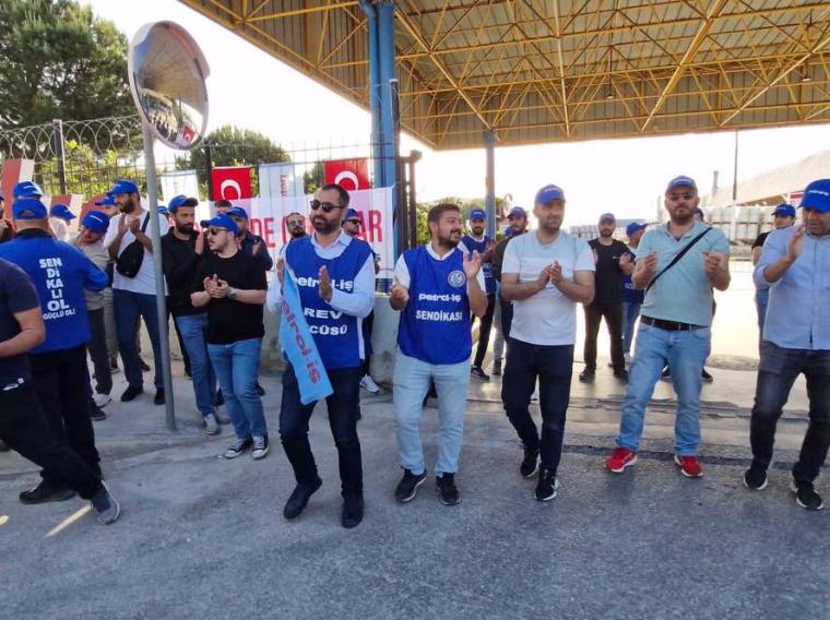 Dyo Boya Fabrikası önünde, Petrol İş Sendikası üyeleri grevde, el ele tutuşarak slogan atıyor ve dans ediyor.