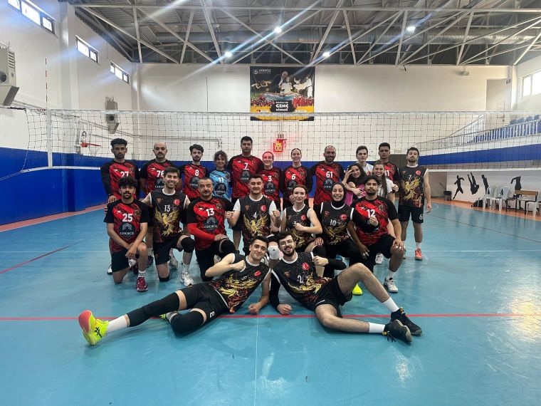 Voleybol takımının, turnuvada birlikte poz verdiği bir grup fotoğrafı. Üyeler, takım formaları içinde gülümsüyor.