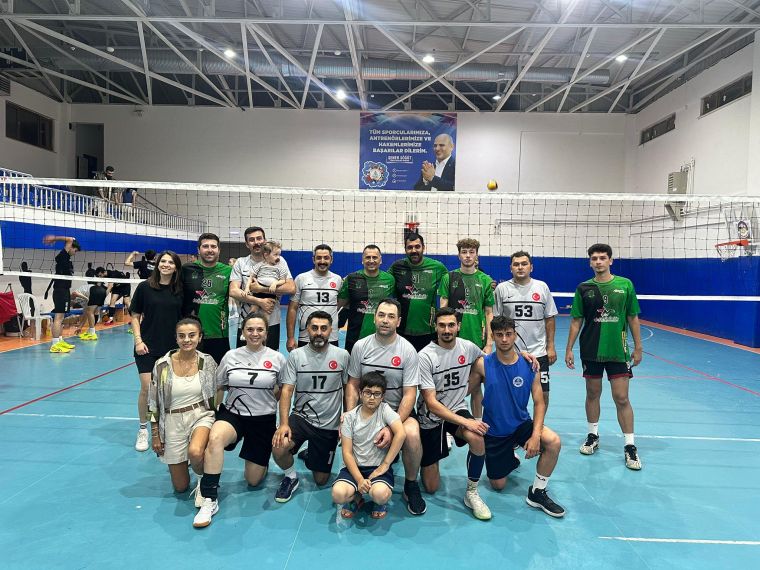 Kocaeli'de düzenlenen Olbia Group Voleybol Turnuvası'nda bir takım, voleybol sahasında birlikte poz veriyor. Arka planda voleybol fileleri ve tribünler yer alıyor.