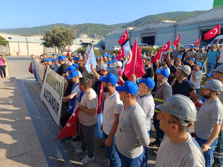 Gübretaş çalışanları, toplu sözleşme görüşmeleri sonrası protesto düzenlemek için bir araya geldi. Çalışanlar, ön planda bir pankart tutarak ve Türk bayraklarıyla slogan atıyor.
