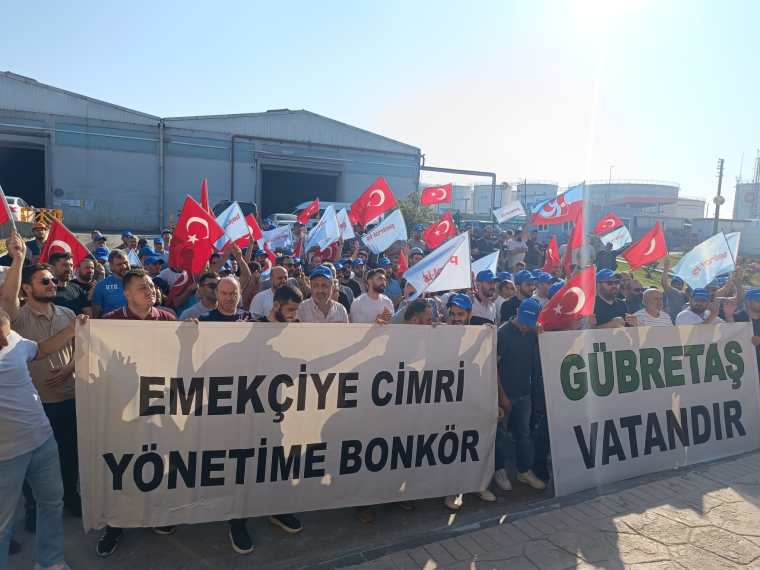 Gübretaş işçileri, maaş zammı talebiyle protesto düzenleyerek pankartlar ve bayraklarla toplandıkları bir görüntü.